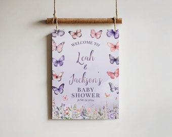 May include: A purple and white baby shower sign with butterflies and flowers. The sign says "Welcome to Leah & Jackson's Baby Shower June 20, 2024".