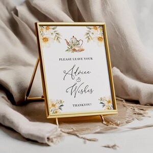 May include: A gold-framed sign with a white background and floral accents. The sign reads "Please leave your Advice & Wishes Thank You!" and features a watercolor illustration of a teapot and teacup.