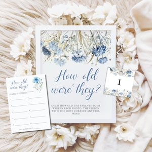 May include: Baby shower game cards with a floral design. The main card reads "How old were they?" in blue script. Additional cards include a game card and a card with the number "I". The cards are decorated with blue flowers.