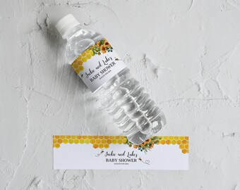 May include: Water bottle label with a yellow and white honeycomb pattern and floral design. The label says "Jackie and Luke's Baby Shower".