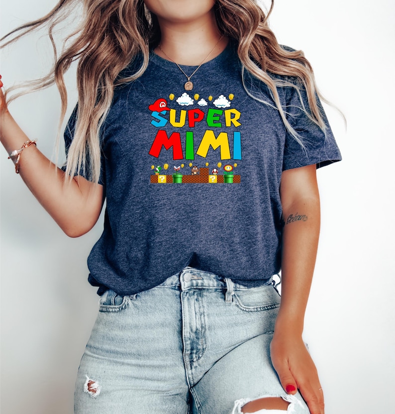May include: A navy blue t-shirt with a graphic of a video game character and the text "SUPER MIMI" in colorful letters.