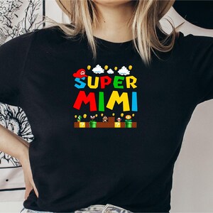 May include: Black t-shirt with a colorful graphic of a video game character with the text "SUPER MIMI" on it.