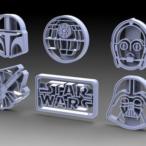 Könnte beinhalten: Ein Set mit sechs grauen Plastik-Ausstechern mit Star Wars-Charakteren und -Logos. Die Ausstecher beinhalten Darth Vader, C-3PO, Boba Fett, den Millennium Falcon, den Todesstern und das Star Wars-Logo.