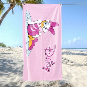 K&ouml;nnte beinhalten: Rosa Strandtuch mit einem Cartoon-Bild von Daisy Duck in einem rosa Kleid mit einer gelben Schleife. Das Handtuch tr&auml;gt den Text "Disney Daisy" in rosa Schrift.