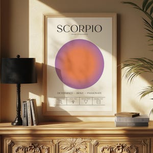 May include: A framed Scorpio zodiac sign art print. The print features the word "SCORPIO" in black, with the dates October 23 - November 21. A purple and orange gradient circle is in the center. The words "DETERMINED BRAVE PASSIONATE" are below the circle.