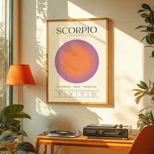 May include: A framed Scorpio zodiac sign art print. The print features the word "SCORPIO" above a gradient circle in shades of orange and purple. Below the circle are the words "DETERMINED BRAVE PASSIONATE".