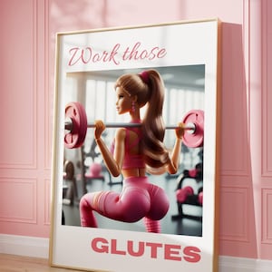 Pode incluir: Um pôster motivacional com uma boneca Barbie levantando pesos em uma academia. O pôster tem o texto "Work those Glutes" em letras cor-de-rosa.