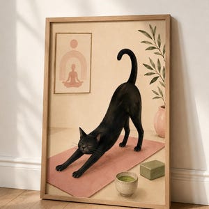 May include: A framed wall art print featuring a black cat stretching on a pink yoga mat. The illustration includes a small bowl of green liquid, a green rectangular block, a potted plant, and a framed picture of a person in a yoga pose.
