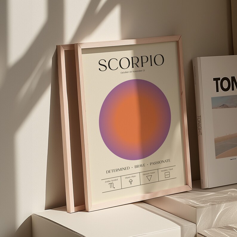 May include: Framed art print featuring the word "SCORPIO" in black text above a gradient circle in purple and orange. The print includes zodiac symbols and the words "Determined, Brave, Passionate."