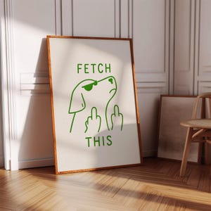 Könnte beinhalten: Ein gerahmter Kunstdruck mit einer grünen Hundeillustration, die eine Sonnenbrille trägt und den Mittelfinger zeigt. Der Text "FETCH THIS" steht über und unter dem Hund. Der Rahmen ist braun und der Hintergrund cremefarben.
