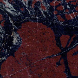 Puede incluir: Primer plano de una superficie de m&aacute;rmol rojo y azul con un patr&oacute;n de remolino. La superficie tiene una textura rugosa y un aspecto natural.