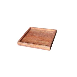 May include: A square, reddish-brown tray with a raised border. The tray has a natural, textured appearance, suggesting it is made of stone or a similar material. The edges show a lighter, weathered color.
