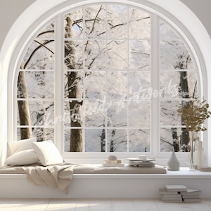May include: A white room with a large arched window overlooking a snowy forest. The window is divided into panes and has a white windowsill. There are two white bookshelves on either side of the window, filled with books. A white cushion and a beige blanket are on the windowsill, creating a cozy reading nook.