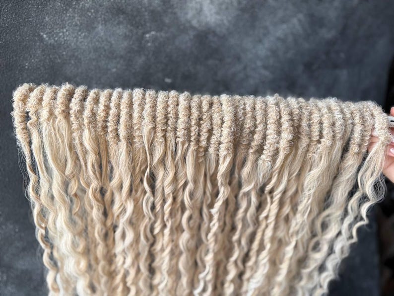 May include: A bundle of long, blonde, curly hair extensions. The hair is in a loose braid and the ends are curled.
