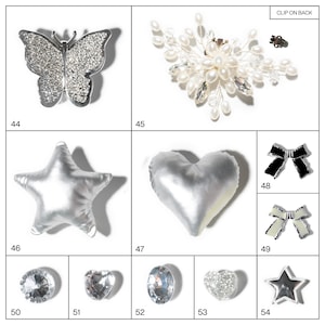 May include: A collection of jewelry and accessories, including a rhinestone butterfly brooch, a pearl and crystal hair clip, and various rhinestone and fabric embellishments in star, heart, and bow shapes. The items are silver and white.