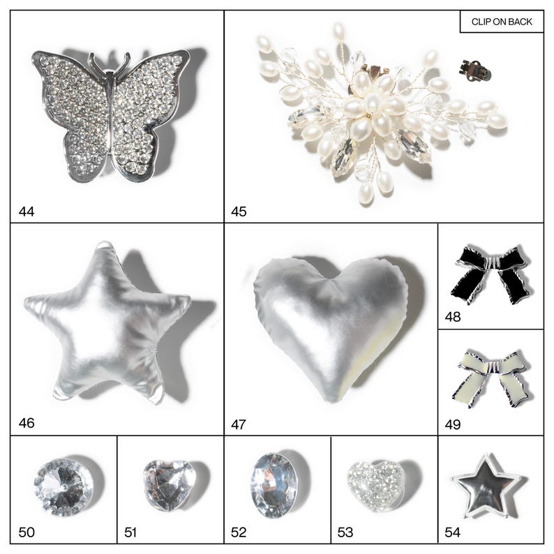 May include: A collection of jewelry and accessories, including a rhinestone butterfly brooch, a pearl and crystal hair clip, and various rhinestone and fabric embellishments in star, heart, and bow shapes. The items are silver and white.