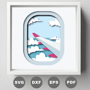 May include: A papercraft design of an airplane wing seen through an airplane window. The wing is pink and white, and the window is framed in blue. The background is a blue sky with white clouds.