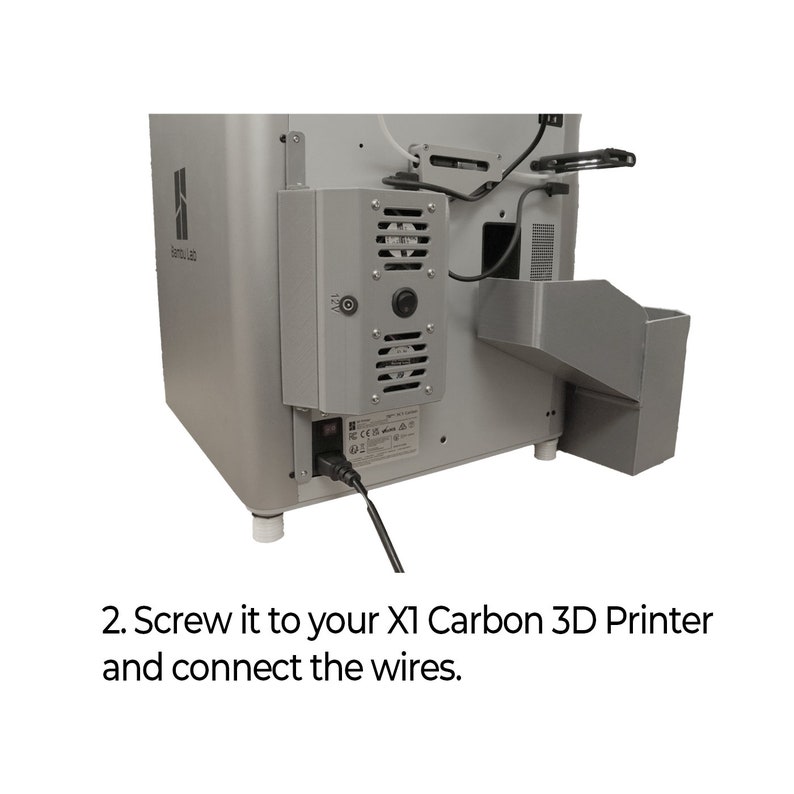 May include: A close-up of the back of a grey 3D printer with a power cord plugged in. The text "X1 Carbon 3D Printer" is visible in the image.