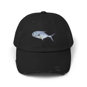 May include: A black distressed baseball cap with a white and blue illustration of a fish on the front.