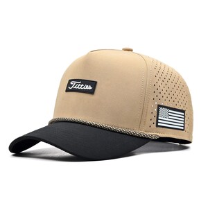 May include: Tan and black baseball cap with the word "Titties" on the front. The cap has a black brim and a small American flag patch on the side. The cap is made of a breathable material.