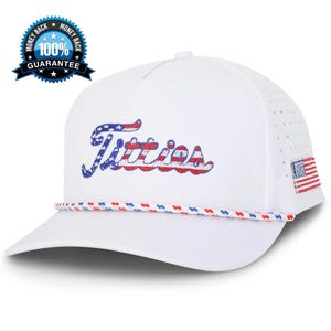 May include: White baseball cap with the word "Titties" embroidered in red, white, and blue, resembling the American flag. Features a small American flag patch on the side and a rope detail around the brim. Includes a "100% Guarantee" badge.