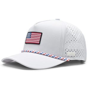 May include: A white baseball cap featuring a rectangular patch of the American flag on the front panel. The cap includes a red, white, and blue braided rope detail across the base of the crown and perforated side panels for ventilation.