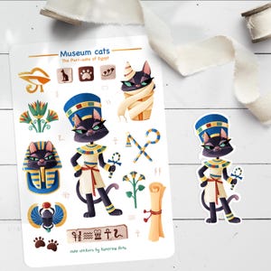 May include: A sticker sheet with cartoon cats dressed as ancient Egyptians. The designs include cats in pharaoh headdresses, wrapped in bandages, and holding ankhs. The text "Museum cats" and "The Purr-aohs of Egypt" are displayed on the sheet.