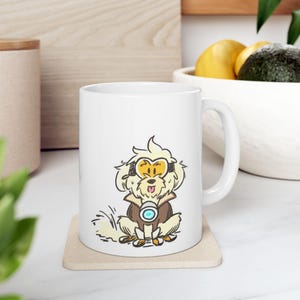 Könnte beinhalten: Weiße Keramiktasse mit einem Cartoon-Hund, der eine gelbe Brille und eine braune Jacke trägt. Der Hund sitzt auf einem beigen Untersetzer. Die Tasse hat einen großen Henkel und steht auf einer weißen Oberfläche.