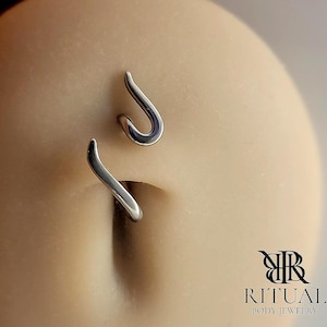 May include: A silver body piercing with a curved design. The piercing is made of surgical steel and is suitable for a variety of body piercings.