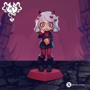 May include: A figurine of a character with white hair, red eyes, and heart-shaped accents. The figure wears a black outfit with red accents and boots, holding a small orange object. The figurine stands on a red heart-shaped base.