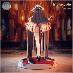 May include: A figurine of a character from Azur Lane, labelled "Implacable." The figure has blonde hair, a black veil, and a gold halo. It is wearing a black and white outfit with a red base. The figure is holding a small cup.
