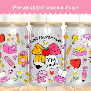 Puede incluir: Tres vasos de vidrio transparente con tapas de madera y pajitas, decorados con gráficos temáticos escolares. Cada vaso presenta un diseño diferente, que incluye manzanas, lápices, libros y el texto "Best Teacher Ever" y "Mrs. Smith". El banner superior dice "Personalized teacher name".