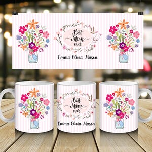 Puede incluir: Taza de cerámica blanca con un diseño floral. El diseño incluye un ramo de flores coloridas en un tarro de albañil, con el texto "Best Mom ever" y un nombre. El fondo es un patrón de rayas rosas y blancas.