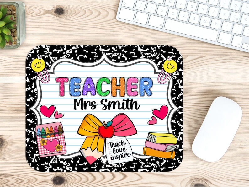 May include: A rectangular mousepad with a black and white speckled border. The center features a lined paper design with the word "TEACHER" in colorful letters and "Mrs. Smith" below. A pencil, apple, and bow graphic is present, along with hearts, crayons, and books.