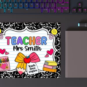 May include: A rectangular mousepad with a composition notebook design. The mousepad features the word "TEACHER" in colorful letters, the name "Mrs. Smith", and school-themed graphics like hearts, pencils, and books. A keyboard and a notebook are in the background.
