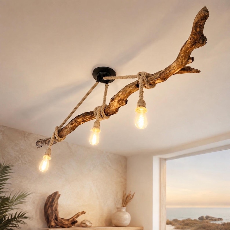 May include: A ceiling light fixture featuring a natural brown driftwood branch suspended by a black circular mount. Three light bulbs hang from the branch, each wrapped in thick beige rope cord, providing warm illumination to the room below.