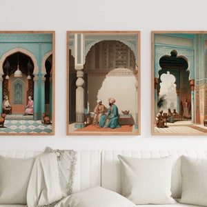 May include: Three framed prints depicting scenes from a traditional Middle Eastern courtyard. The prints feature intricate architectural details, including arches, columns, and tiled floors. The central print shows two figures seated on a rug, while the other two prints show empty courtyards.