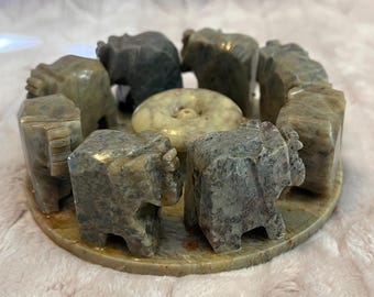 handcrafted soapstone or marble incense burner featuring a circle of small elephant figurines