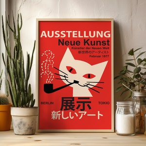 Puede incluir: Un póster rojo con un gato blanco fumando una pipa. El póster se titula "AUSSTELLUNG Neue Kunst" e incluye el texto "Künstler der Neuen Welt" y "新世界のアーティスト" en japonés. El póster también incluye el texto "Februar 1977", "BERLIN", "展示", "TOKIO" y "新しいアート" en japonés.