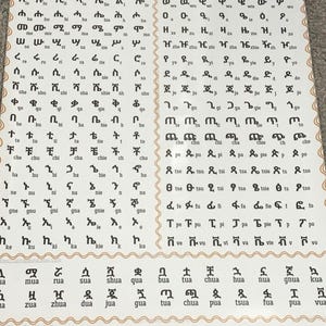 Puede incluir: Un póster con el alfabeto etíope, con ejemplos de letras y números. El póster muestra la escritura etíope, con ejemplos de letras y números del 1 al 100. El fondo es de color beige claro.