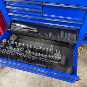 May include: A blue metal toolbox with a drawer open, revealing a variety of tools, including sockets, wrenches, and screwdrivers.