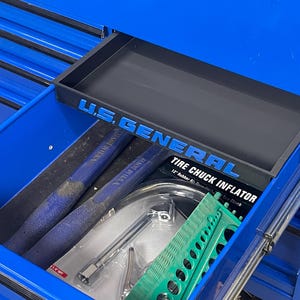 May include: A blue tool chest drawer filled with tools. The drawer contains a black tray with the text "U.S. GENERAL". Tools include blue handled punches, a tire chuck inflator, and a green tool.