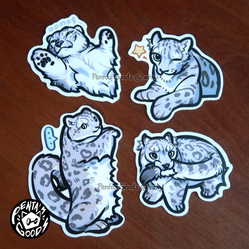 May include: Four stickers featuring cartoon snow leopards in various poses. One sticker shows a snow leopard with the word "oompf" in a speech bubble. The stickers have a white border and are on a brown surface.