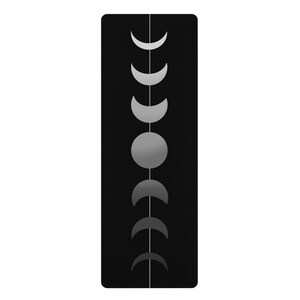 May include: A black yoga mat with a white line down the centre and a series of grey crescent moons in different phases.