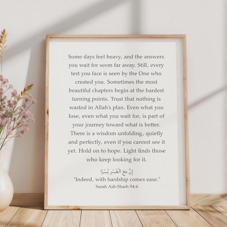 May include: A framed wall art print featuring black text on a white background. The text reads: Some days feel heavy, and the answers you wait for seem far away. Still, every test you face is seen by the One who created you. Indeed, with hardship comes ease. Surah Ash-Sharh 94:6.