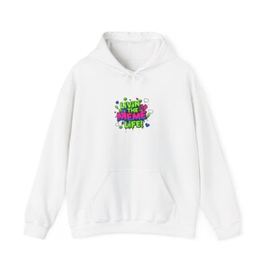 May include: White hoodie with a front pocket and drawstring hood. The front displays a colourful graphic that reads "Livin' the Meme Life!" in a playful, graffiti-style font with hearts and speech bubbles.