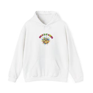 May include: White hooded sweatshirt with a front pocket and a drawstring. The front displays a colourful graphic with the text "Chaos is my cardio" above a design of emoji faces and splashes of colour.