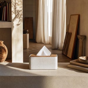 Rectangular PU leather tissue box cover with linen‑style beige texture and stitched wooden top, designed to fit standard Kleenex rectangular boxes. Features a modern, minimalist look that blends seamlessly with home décor styles from contemporary to boho. Durable magnetic closure allows easy tissue replacement, while the elegant design makes it perfect for bathroom, bedroom, living room, or office use. A stylish and functional home accessory or thoughtful gift idea.