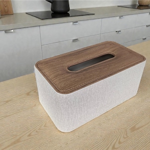 Rectangular PU leather tissue box cover with linen‑style beige texture and stitched wooden top, designed to fit standard Kleenex rectangular boxes. Features a modern, minimalist look that blends seamlessly with home décor styles from contemporary to boho. Durable magnetic closure allows easy tissue replacement, while the elegant design makes it perfect for bathroom, bedroom, living room, or office use. A stylish and functional home accessory or thoughtful gift idea.