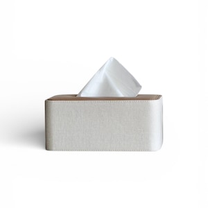 Rectangular PU leather tissue box cover with linen‑style beige texture and stitched wooden top, designed to fit standard Kleenex rectangular boxes. Features a modern, minimalist look that blends seamlessly with home décor styles from contemporary to boho. Durable magnetic closure allows easy tissue replacement, while the elegant design makes it perfect for bathroom, bedroom, living room, or office use. A stylish and functional home accessory or thoughtful gift idea.